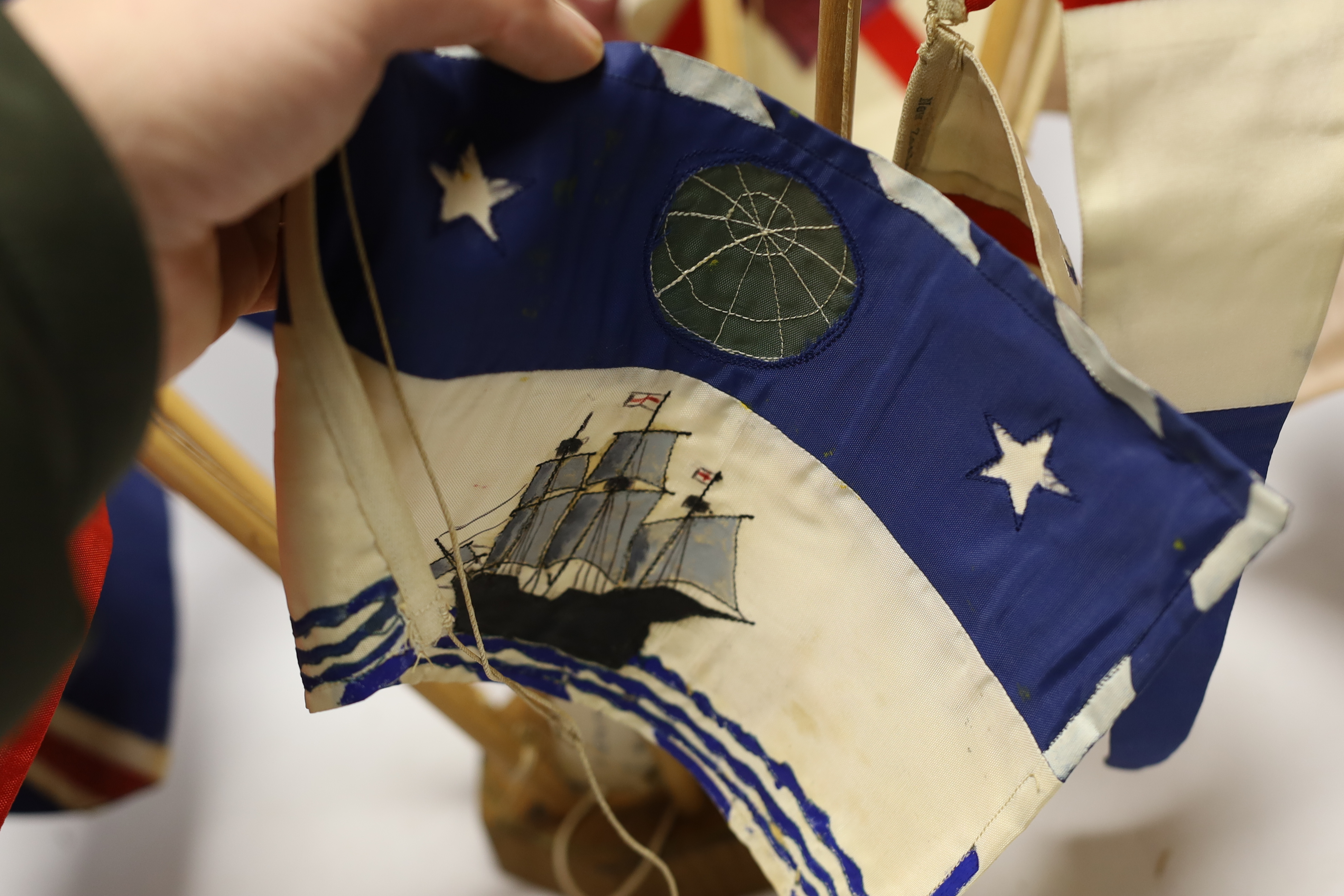 Collection of mid 20th century merchant shipping pennants on a stand and a boxed George V silver model of an oar, inscribed ‘Second Destroyer Flotilla Regatta 1934’
